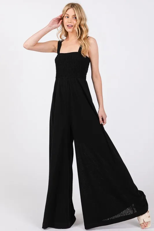 Black smocked flowy wide leg jumpsuit in cotton blend with adjustable straps