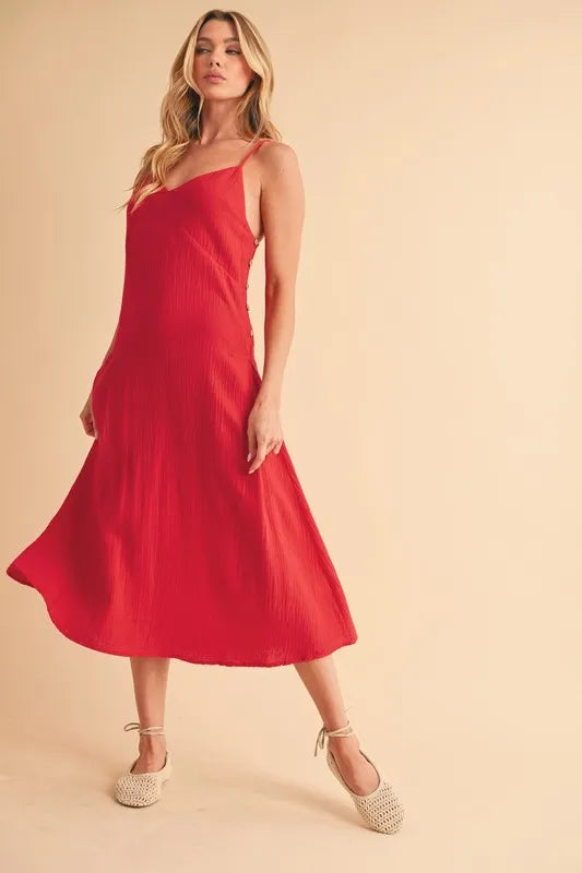 Woman wearing a midi cami dress with side buttons, made from 100% cotton, perfect for summer or casual wear