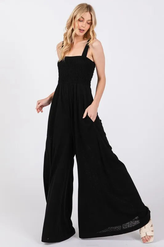 Black smocked flowy wide leg jumpsuit in cotton blend with adjustable straps